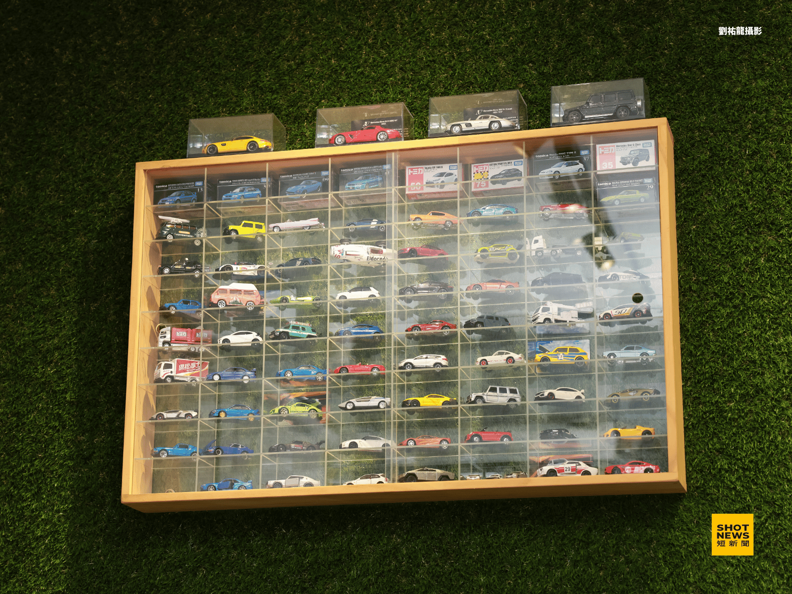 車行內的牆壁上，梁子謙有不少玩具車收藏。
