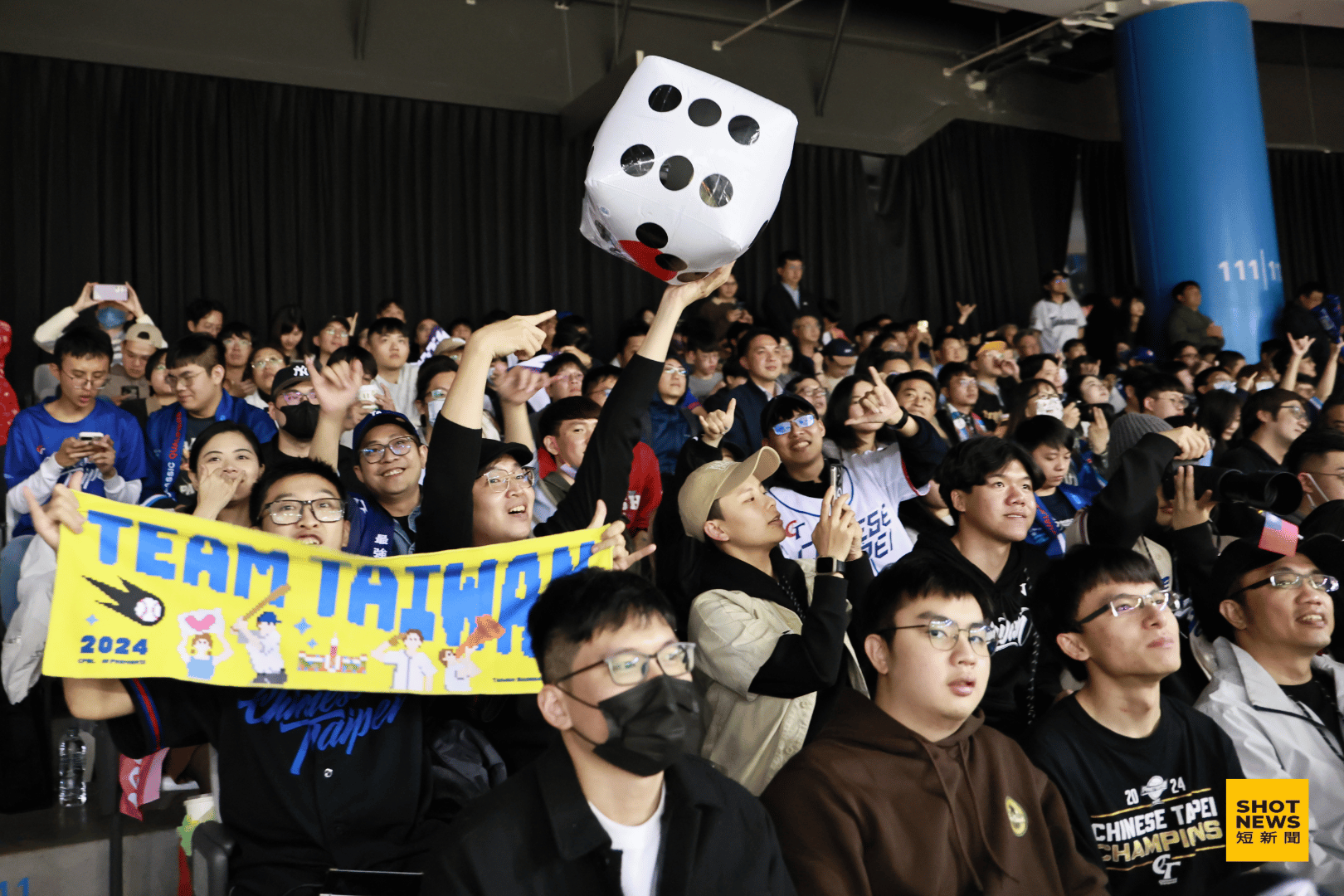 台灣球迷攜帶「Team Taiwan」毛巾與象徵幸運的骰子進場應援。(劉祐龍攝影)