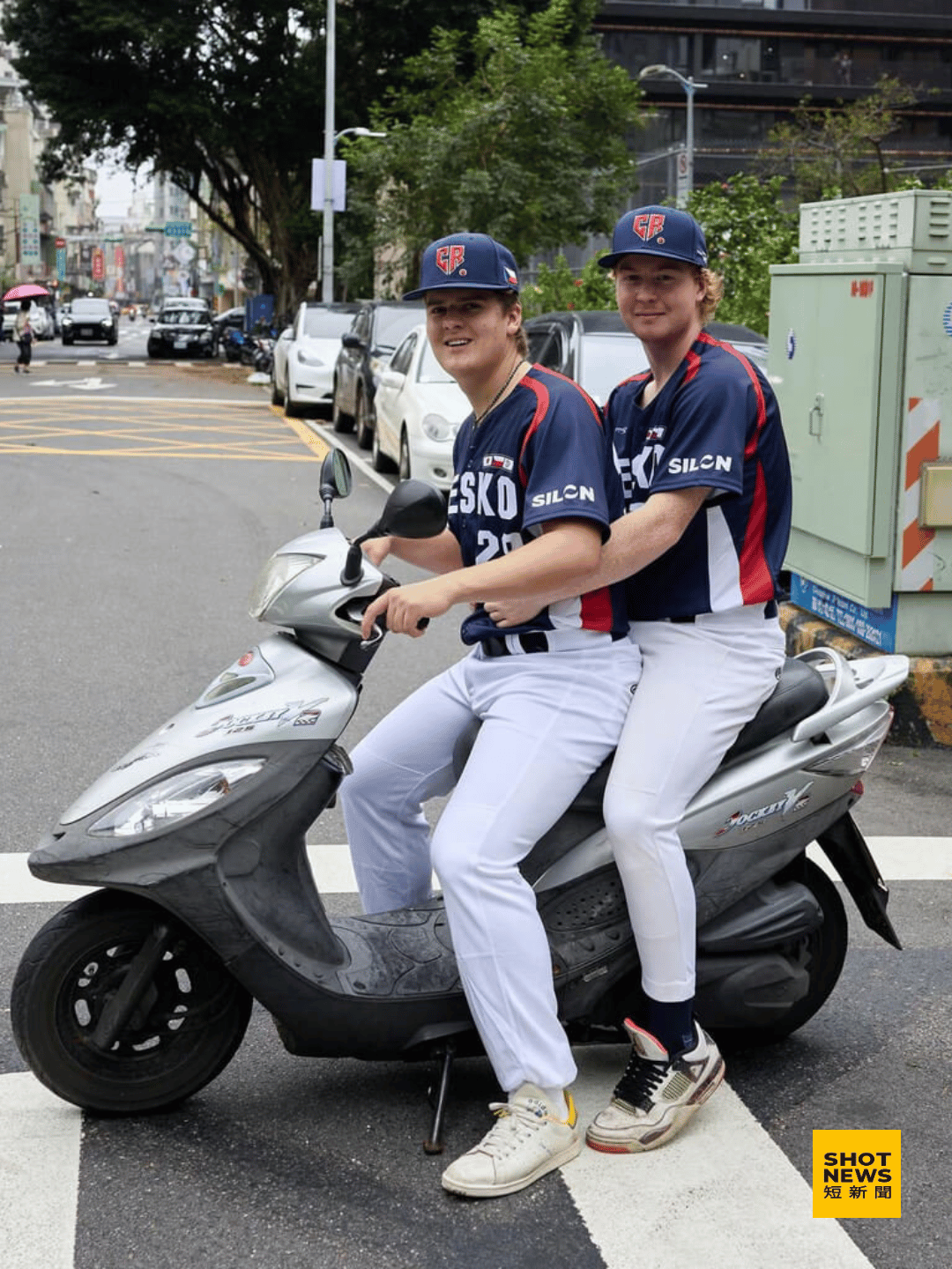 捷克選手在台灣街頭向一位路人借機車拍照。（圖：中央社）