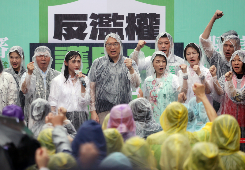 民進黨秘書長林右昌率領黨公職，在滂沱大雨中仍繼續宣講活動。(圖：中央社)