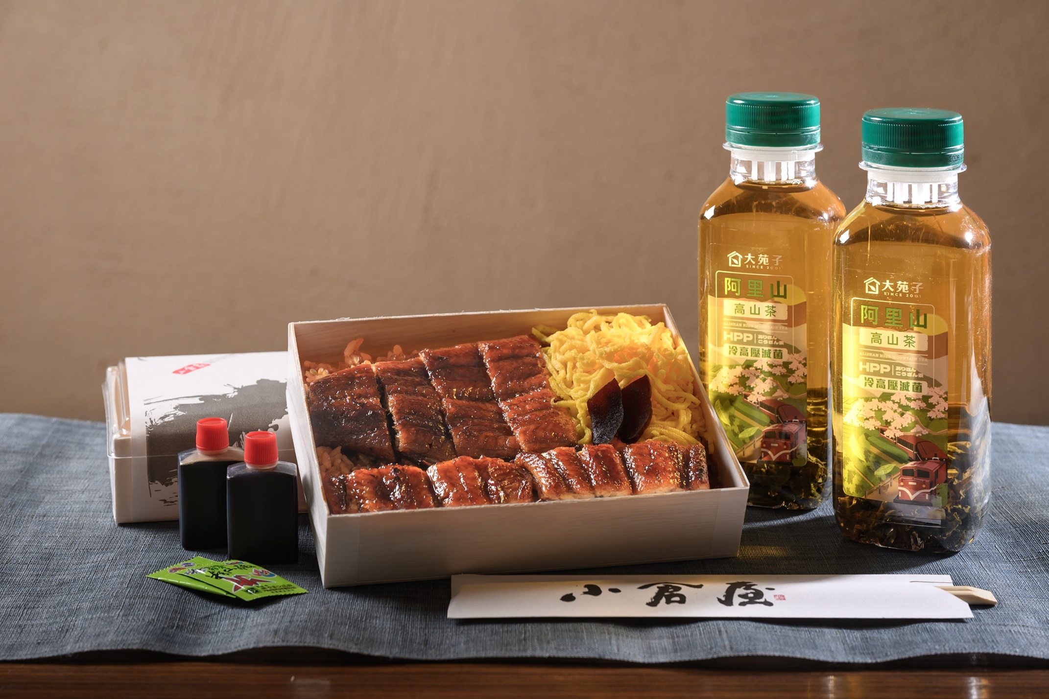 小倉屋台北光復本店於7月26日土用丑日可享「鰻蒸竹定食」便當(售價620元)外帶買一送一,再加碼贈送大苑子阿里山高山冷泡茶一瓶(400ml)一加一瓶,每人限購一份,僅接受現金結帳,當日現場排隊,不列入會員集點,限定100組,售完為止。(圖/小倉屋 提供)