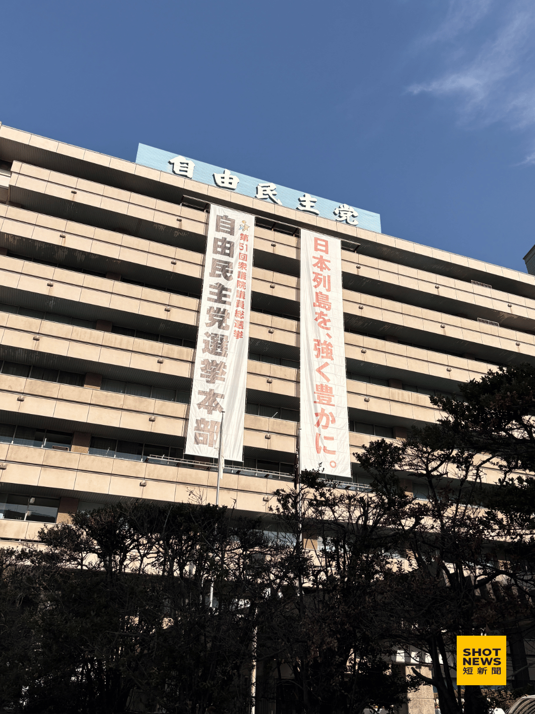 自民黨總部外懸掛,高市早苗與自民黨這次競選主軸「讓日本列島更加強大富裕」的大型布條,喚醒日本民眾對於國家再次強大的期待。(劉祐龍攝影)