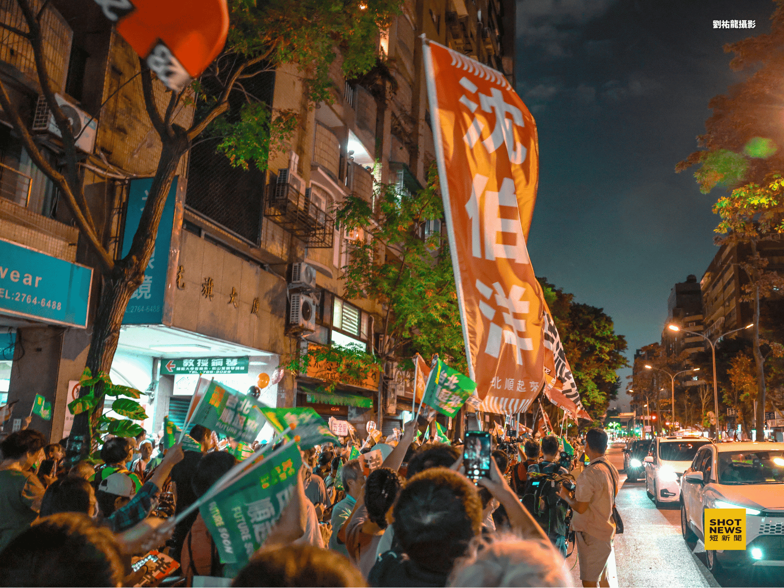 「沈伯洋」大旗在松山街頭揮舞，民眾沿街舉旗跟拍。（攝影：劉祐龍）